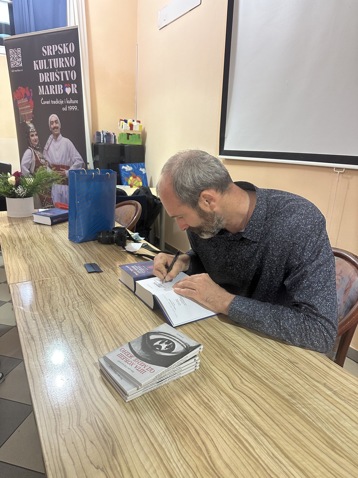 Milan Obradović potpisuje knjige posetiocima promocije